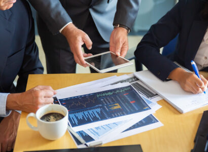 unrecognizable-business-partners-working-with-statistic-charts-businessman-holding-tablet-professional-content-businesswoman-making-notes-statistics-communication-partnership-concept