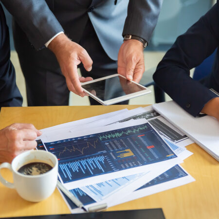 unrecognizable-business-partners-working-with-statistic-charts-businessman-holding-tablet-professional-content-businesswoman-making-notes-statistics-communication-partnership-concept